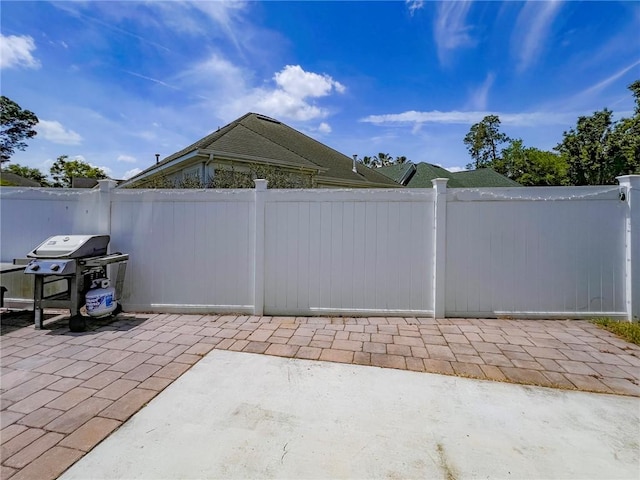 view of patio featuring grilling area and fence