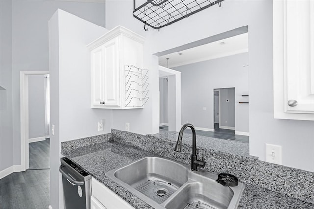 kitchen featuring white cabinets, a sink, dishwasher, dark wood finished floors, and dark stone counters