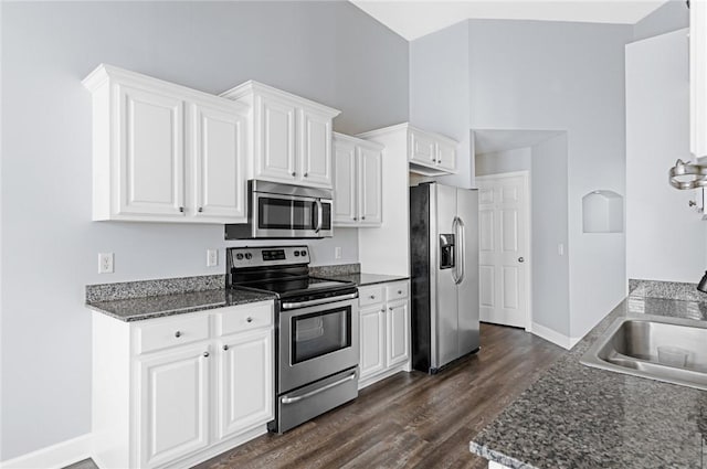 kitchen with dark wood-type flooring, a sink, white cabinets, and stainless steel appliances