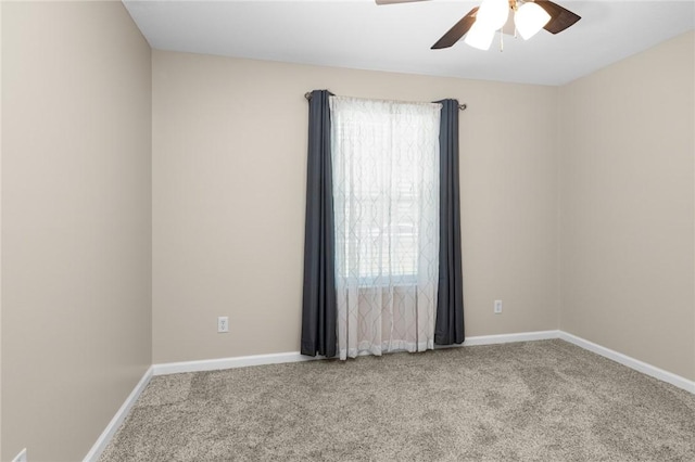 carpeted empty room with baseboards, ceiling fan, and a wealth of natural light