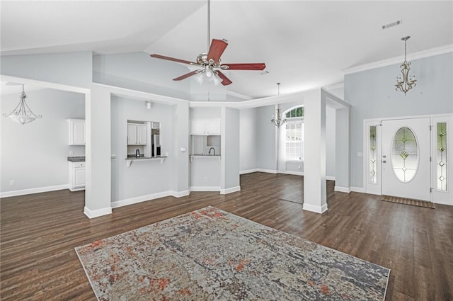 unfurnished living room featuring baseboards, ceiling fan with notable chandelier, dark wood finished floors, and visible vents