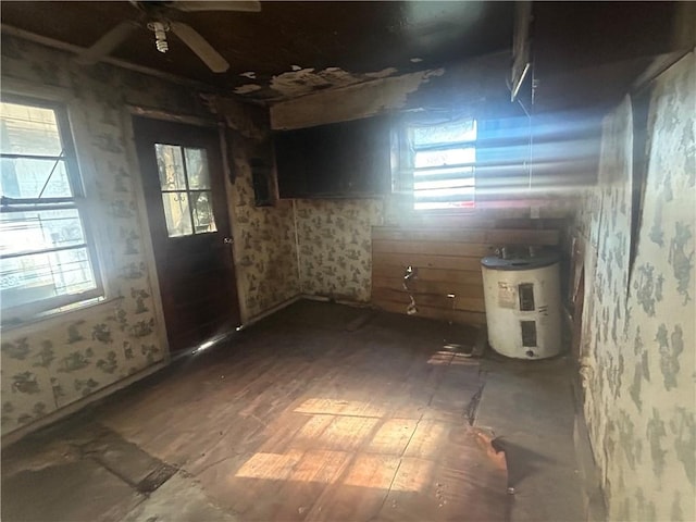 empty room featuring hardwood / wood-style floors, electric water heater, plenty of natural light, and ceiling fan