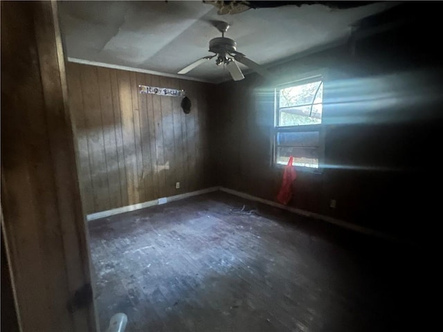 unfurnished room with vaulted ceiling, ceiling fan, and wood walls