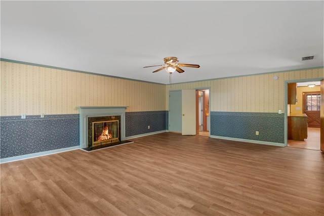 208 Plantation Dr, Waycross, GA 31501 - unfurnished living room with a ceiling fan, wallpapered walls, visible vents, and wood finished floors