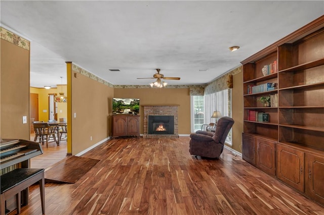 208 Plantation Dr, Waycross, GA 31501 - living area featuring baseboards, a ceiling fan, dark wood-style flooring, and a brick fireplace