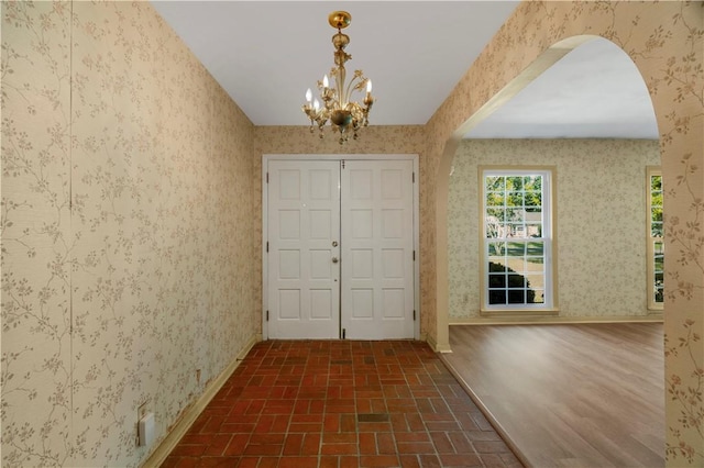 208 Plantation Dr, Waycross, GA 31501 - entrance foyer featuring arched walkways, wallpapered walls, and brick patterned floor