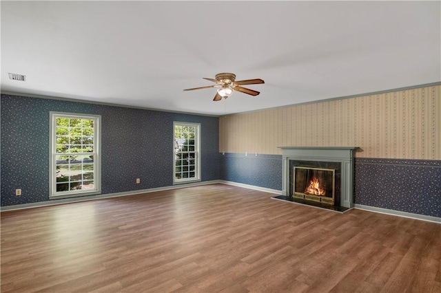 208 Plantation Dr, Waycross, GA 31501 - unfurnished living room featuring ceiling fan, a glass covered fireplace, wood finished floors, and visible vents