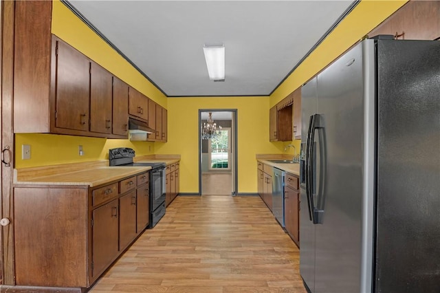 208 Plantation Dr, Waycross, GA 31501 - kitchen with light countertops, under cabinet range hood, a sink, light wood finished floors, and stainless steel appliances