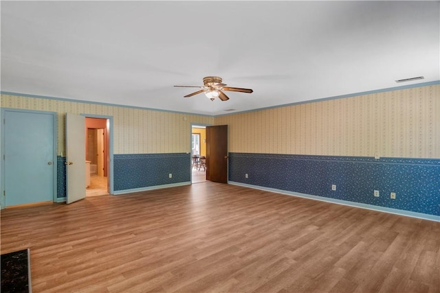 208 Plantation Dr, Waycross, GA 31501 - unfurnished room with visible vents, ornamental molding, wood finished floors, ceiling fan, and wallpapered walls