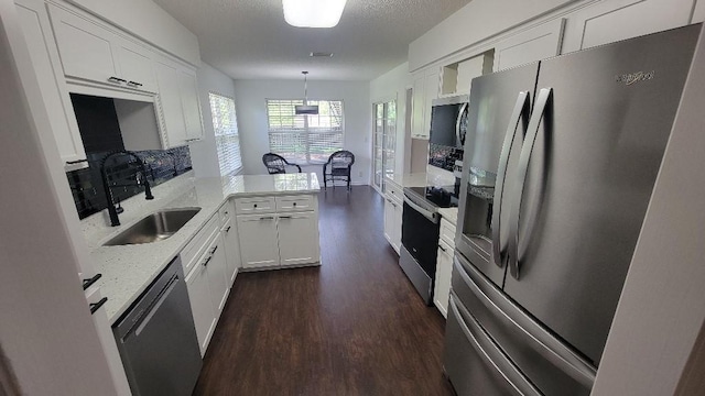 102 Norwood Ct, Brunswick, GA 31525 - kitchen featuring stainless steel appliances, dark wood finished floors, a peninsula, and white cabinetry