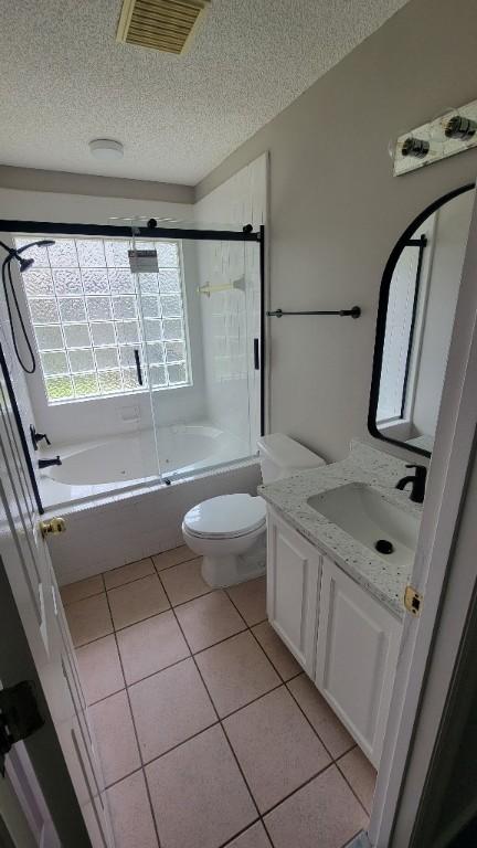 102 Norwood Ct, Brunswick, GA 31525 - bathroom with a textured ceiling, vanity, tile patterned flooring, and combined bath / shower with glass door