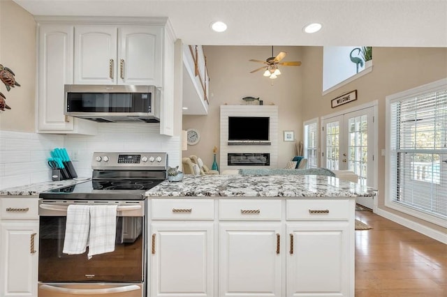 200 Colgana Way, Saint Simons Island, GA 31522 - kitchen with stainless steel appliances, light stone countertops, ceiling fan, white cabinetry, and tasteful backsplash