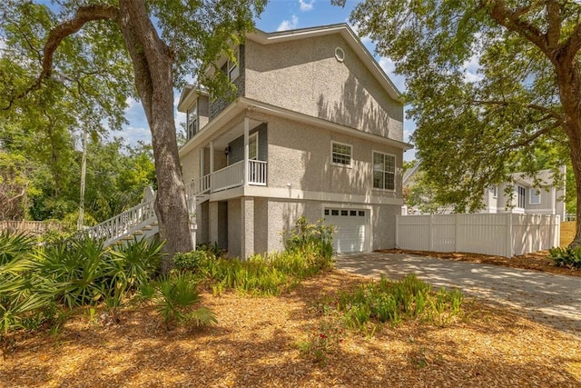 200 Colgana Way, Saint Simons Island, GA 31522 - view of property exterior with stairway, concrete driveway, stucco siding, and an attached garage