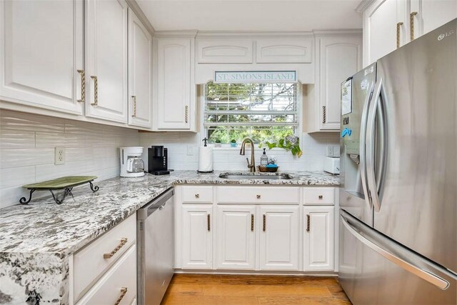 200 Colgana Way, Saint Simons Island, GA 31522 - kitchen with stainless steel appliances, tasteful backsplash, white cabinets, and light stone countertops