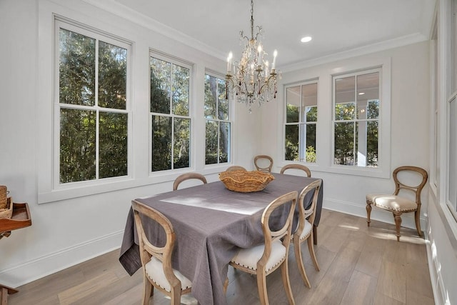 dining space with crown molding, a wealth of natural light, and light hardwood / wood-style flooring