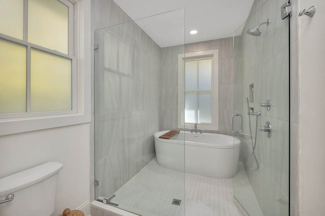 bathroom with tile walls, tile patterned flooring, toilet, and separate shower and tub