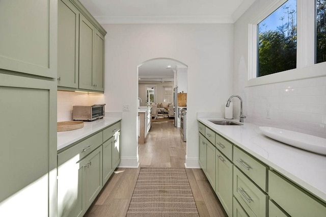 kitchen featuring crown molding, green cabinets, and sink