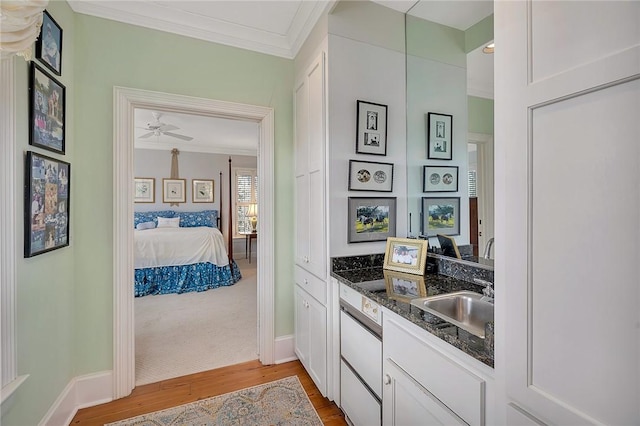 interior space featuring ornamental molding, sink, and light wood-type flooring