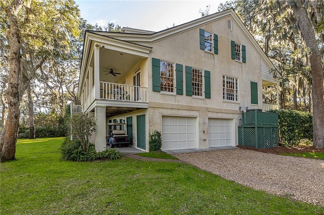 view of front of house featuring a garage, a balcony, a front yard, and ceiling fan