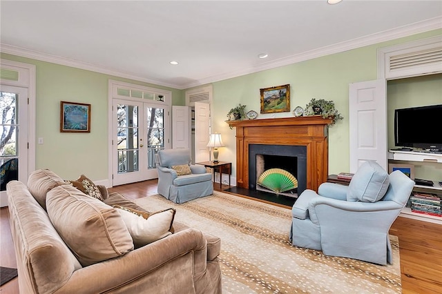 living room with crown molding, wood-type flooring, and french doors