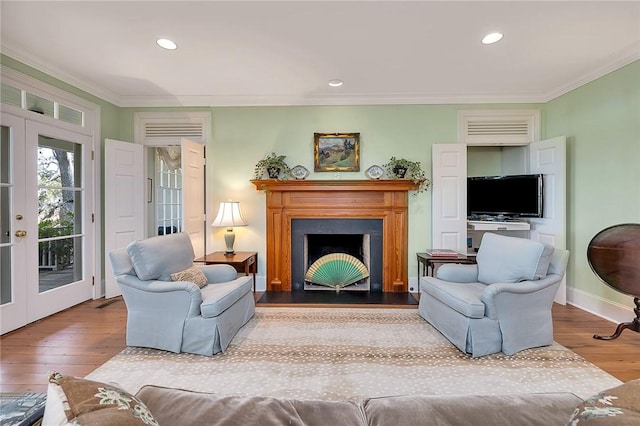 living room featuring wood-type flooring, ornamental molding, and french doors