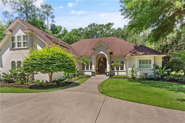 mediterranean / spanish-style home featuring a front yard