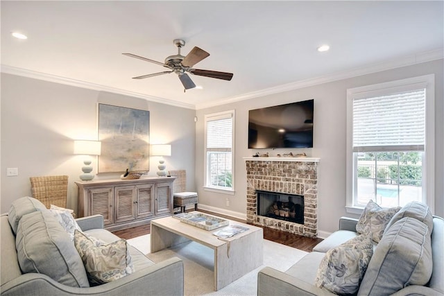 living room with ceiling fan, a fireplace, wood-type flooring, and ornamental molding