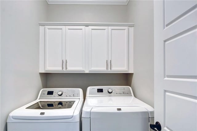 washroom with cabinets and washing machine and dryer