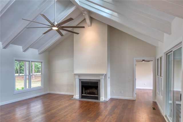 unfurnished living room featuring a fireplace with flush hearth, beam ceiling, baseboards, and wood finished floors