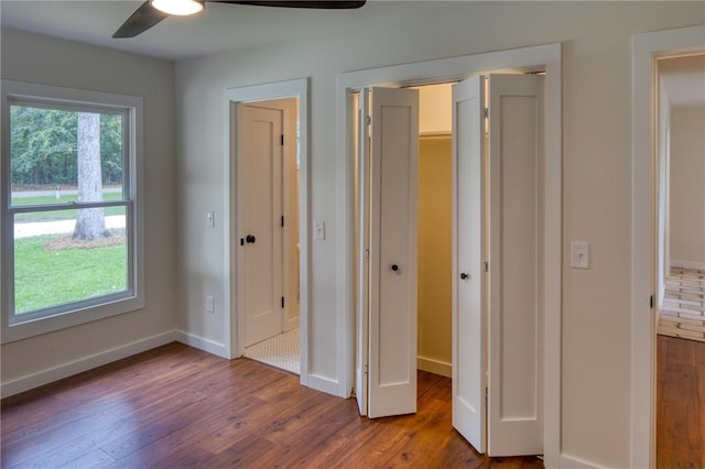 unfurnished bedroom featuring a ceiling fan, baseboards, and wood finished floors