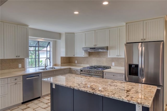 2593 Julienton Dr NE, Townsend, GA 31331 - kitchen featuring appliances with stainless steel finishes, under cabinet range hood, a sink, a kitchen island, and backsplash