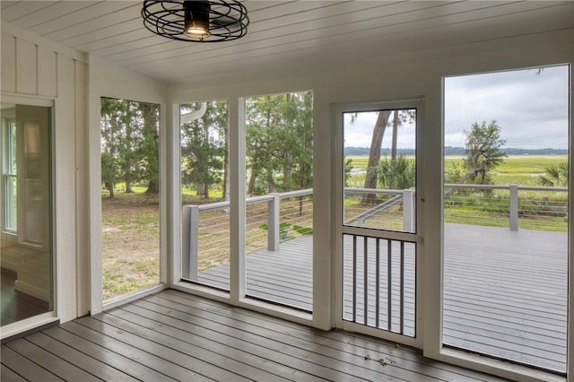 unfurnished sunroom featuring a rural view and ceiling fan