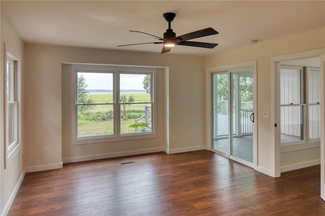 empty room with ceiling fan and dark hardwood / wood-style flooring