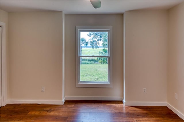 unfurnished room with ceiling fan and dark wood-type flooring