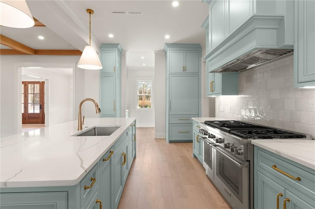 kitchen featuring decorative light fixtures, sink, range with two ovens, custom exhaust hood, and light stone counters