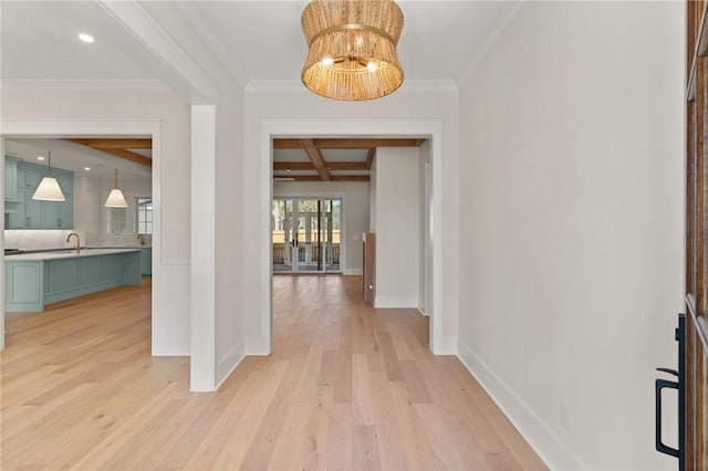 entryway featuring a notable chandelier, light hardwood / wood-style flooring, ornamental molding, and beamed ceiling