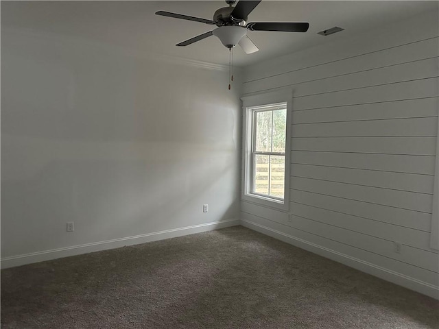 unfurnished room with dark carpet and ceiling fan