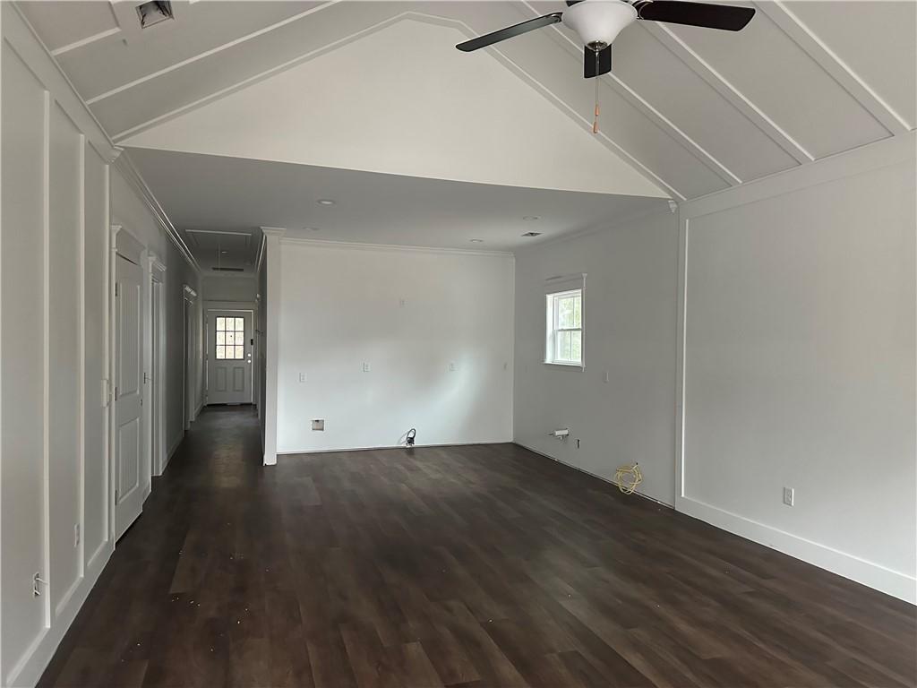 spare room with dark hardwood / wood-style floors, ceiling fan, and lofted ceiling