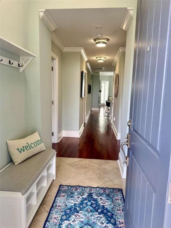 mudroom featuring wood-type flooring and crown molding