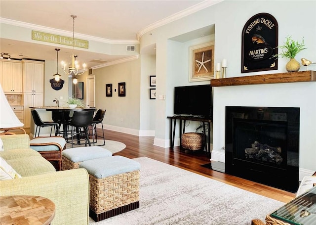 living room featuring crown molding, dark hardwood / wood-style flooring, sink, and an inviting chandelier