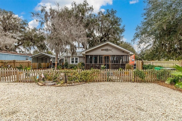 rear view of property featuring a sunroom and a carport