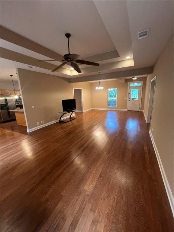 134 Hillery Trce, Brunswick, GA 31523 - unfurnished living room with a ceiling fan, dark wood-style flooring, a chandelier, and a raised ceiling