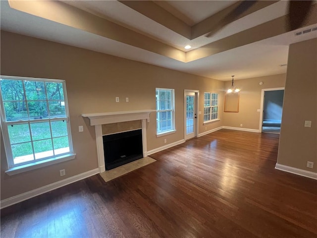 134 Hillery Trce, Brunswick, GA 31523 - unfurnished living room featuring a chandelier, dark wood finished floors, healthy amount of natural light, and a fireplace with flush hearth