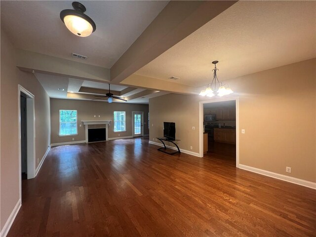134 Hillery Trce, Brunswick, GA 31523 - unfurnished living room featuring wood finished floors, a fireplace, beamed ceiling, ceiling fan, and a chandelier