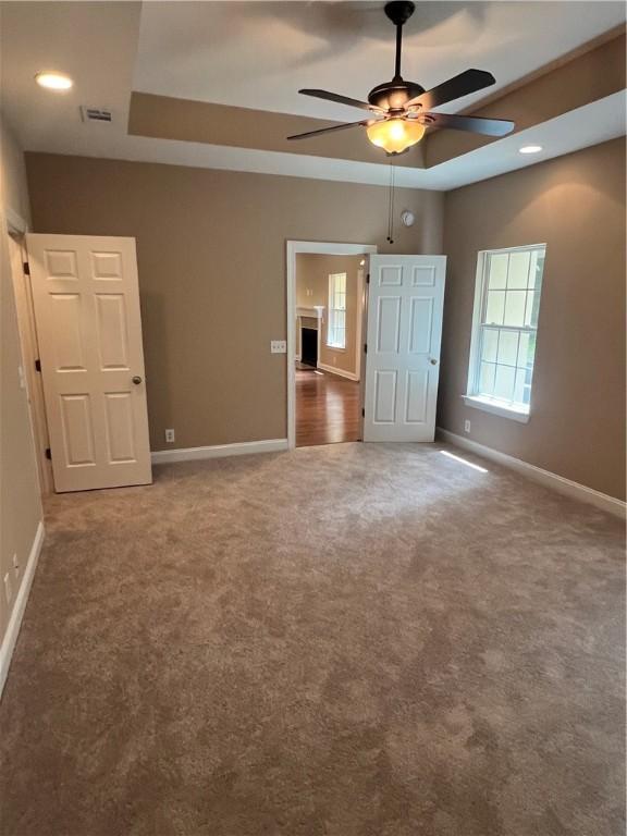 134 Hillery Trce, Brunswick, GA 31523 - unfurnished bedroom featuring carpet flooring, a tray ceiling, and ceiling fan