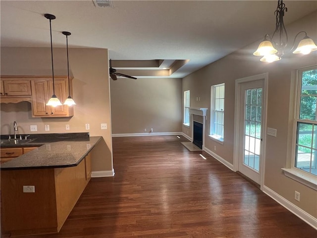 134 Hillery Trce, Brunswick, GA 31523 - kitchen with dark wood-type flooring, a fireplace with flush hearth, a peninsula, and a chandelier