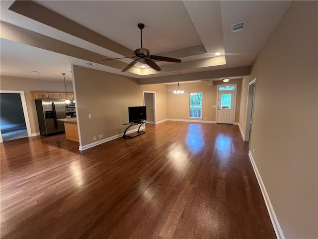 134 Hillery Trce, Brunswick, GA 31523 - unfurnished living room featuring ceiling fan, dark wood-type flooring, a chandelier, and a tray ceiling