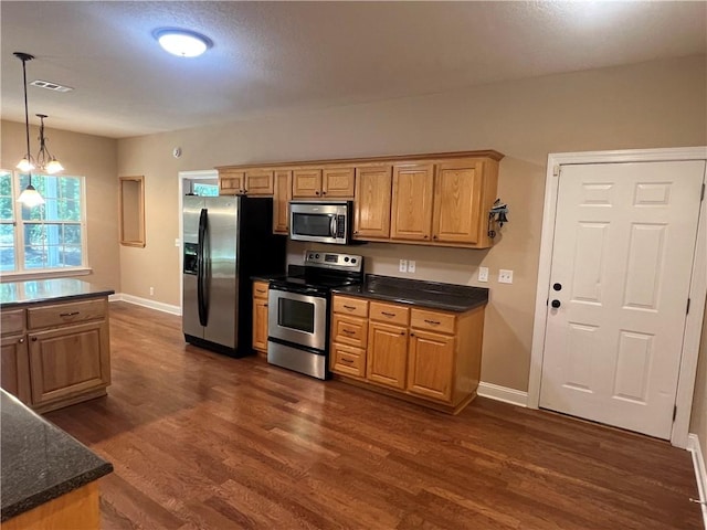 134 Hillery Trce, Brunswick, GA 31523 - kitchen featuring stainless steel appliances, dark wood finished floors, dark countertops, and decorative light fixtures
