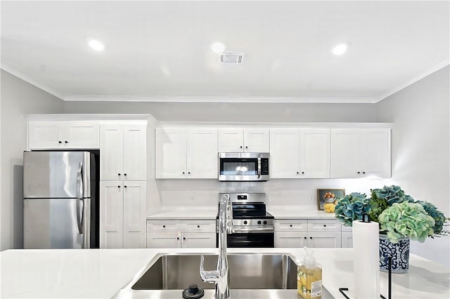 222 Bottlebrush Walk, Brunswick, GA 31525 - kitchen featuring stainless steel appliances, crown molding, light countertops, white cabinetry, and recessed lighting