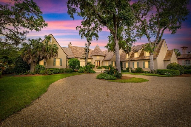 117 Hawkins Island Cir, Saint Simons Island, GA 31522 - view of front of house with stucco siding, curved driveway, and a yard